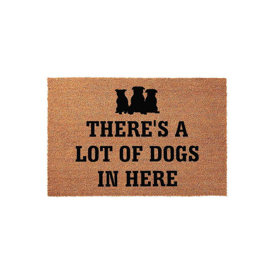 Funny Dog Lover Doormat featuring a natural coir texture with black silhouettes of three dogs and the bold text There is a lot of dogs in here, making it a humorous and welcoming entryway rug for any pet owner home on a plain