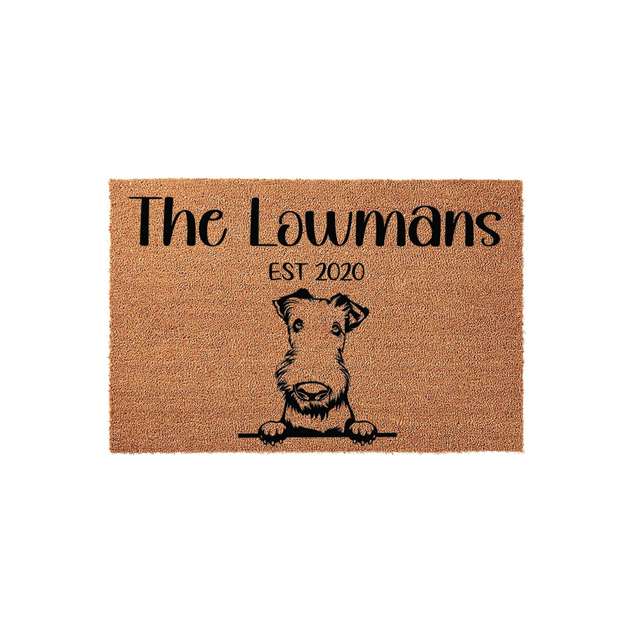 Personalized Airedale Terrier doormat featuring a cute dog illustration peeking over a line, customized with a family name and established year on a natural coir fiber background for a welcoming front porch entrance decor piece.