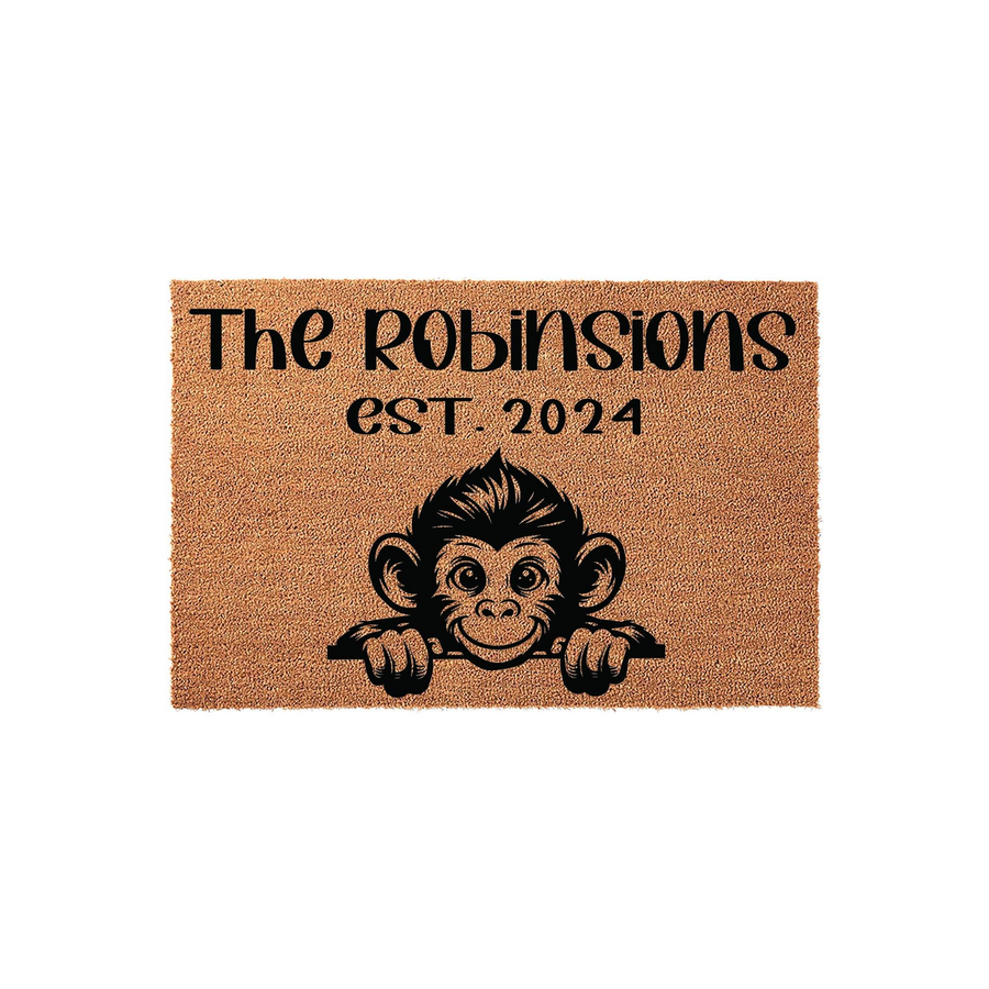 Personalized Monkey Coir Doormat featuring a cute illustrated monkey peeking over the bottom edge, with custom family name text and established year printed in black on a natural brown textured fiber background for a fun entryway.