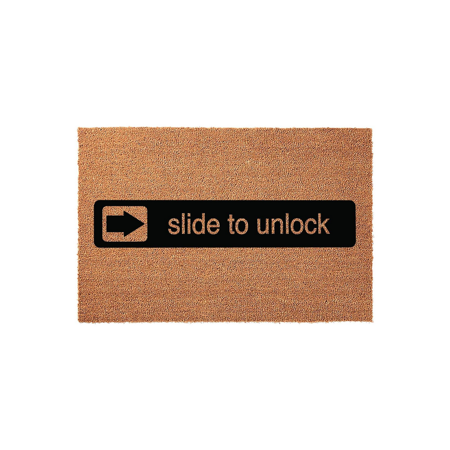 Slide to unlock novelty doormat featuring a rectangular coir mat with a black horizontal bar design that mimics a smartphone interface, complete with a white arrow icon and the text slide to unlock printed in a clean, modern font