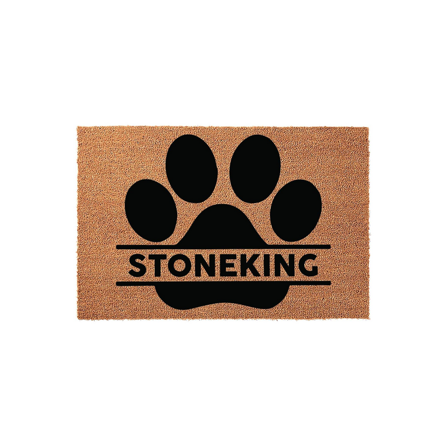 Personalized pet paw print coir doormat featuring a large black paw design with a horizontal split for a custom family name, set against a natural brown textured fiber background for a welcoming and durable entryway floor mat.