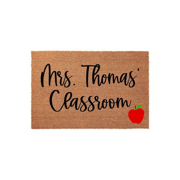 Personalized Teacher Classroom Doormat featuring a natural coir texture with black script text that reads Classroom and a bright red apple icon in the corner, creating a welcoming entrance for a school teacher or classroom door