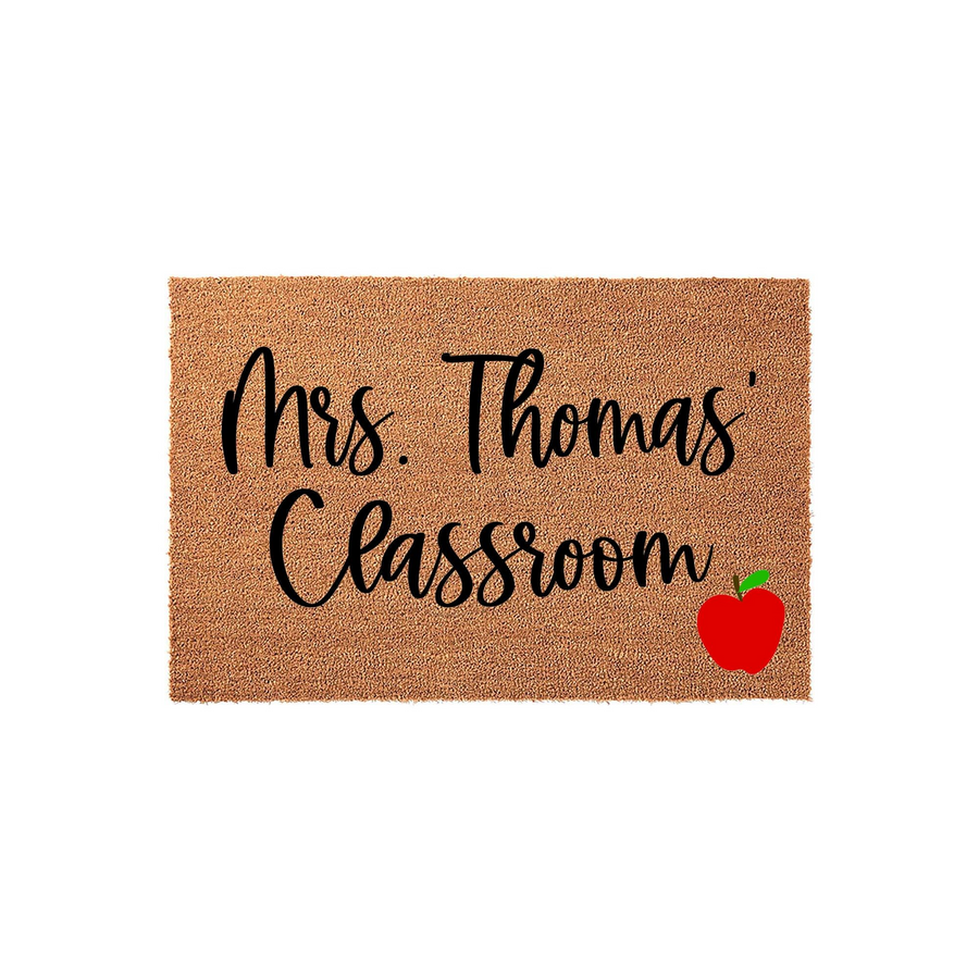 Personalized Teacher Classroom Doormat featuring a natural coir texture with black script text that reads Classroom and a bright red apple icon in the corner, creating a welcoming entrance for a school teacher or classroom door