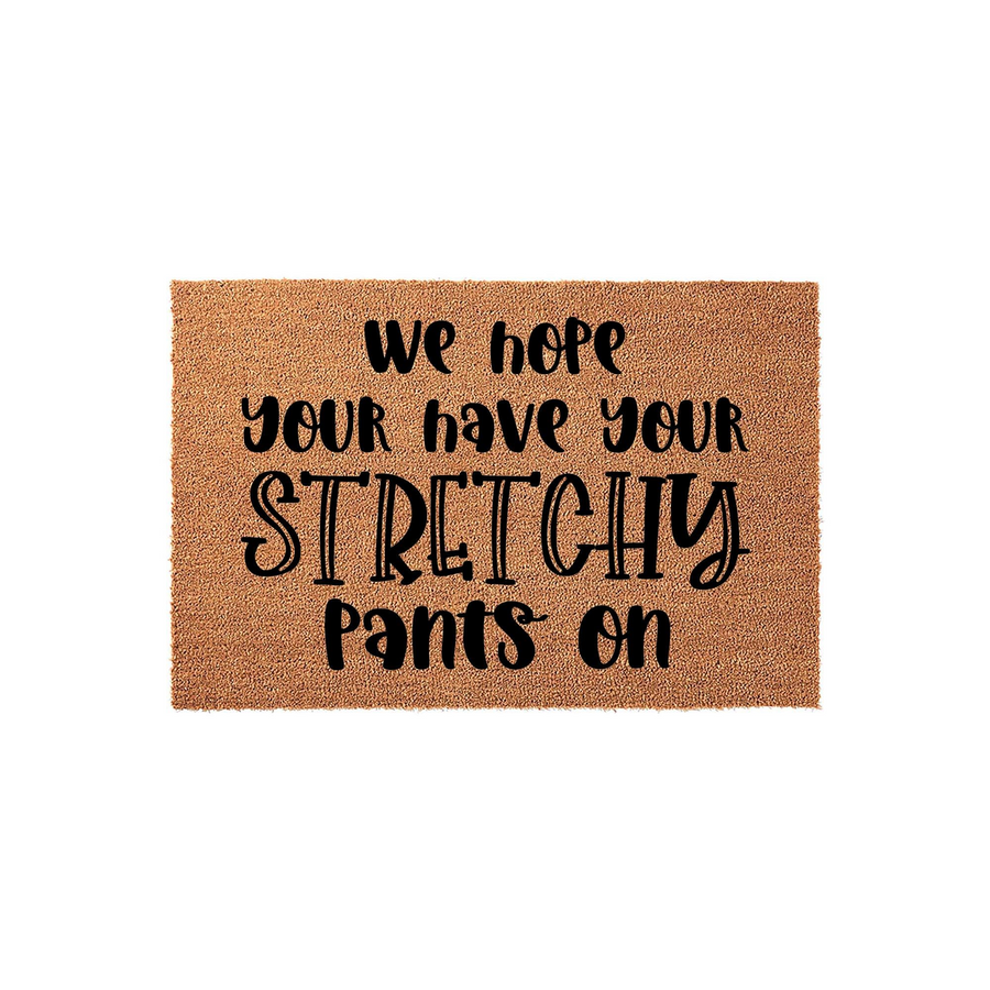 Funny Stretchy Pants Coir Doormat featuring a natural tan fiber texture and bold black lettering that reads We Hope You Have Your Stretchy Pants On, making it a humorous and welcoming addition to any front porch or entryway floor.