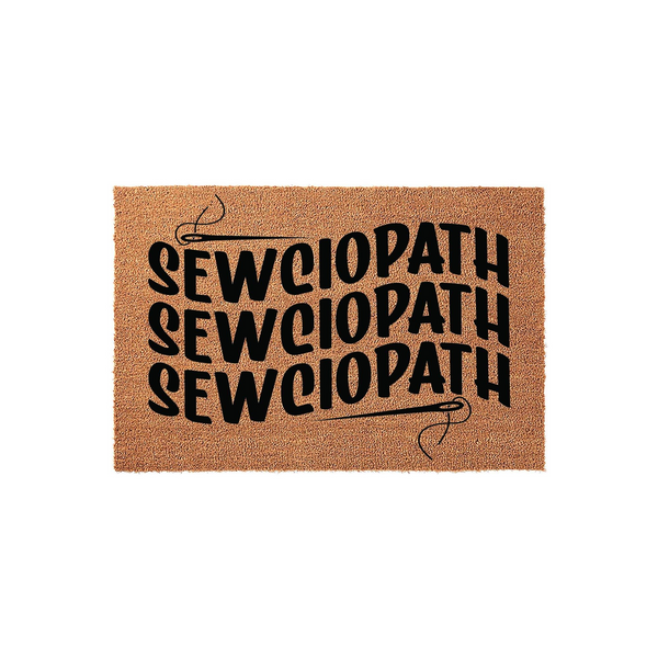 Sewciopath Coir Doormat featuring a humorous sewing-themed design with bold black text and a needle graphic, set against a natural tan fiber background that is ideal for a craft room or a sewing enthusiast's home entryway.