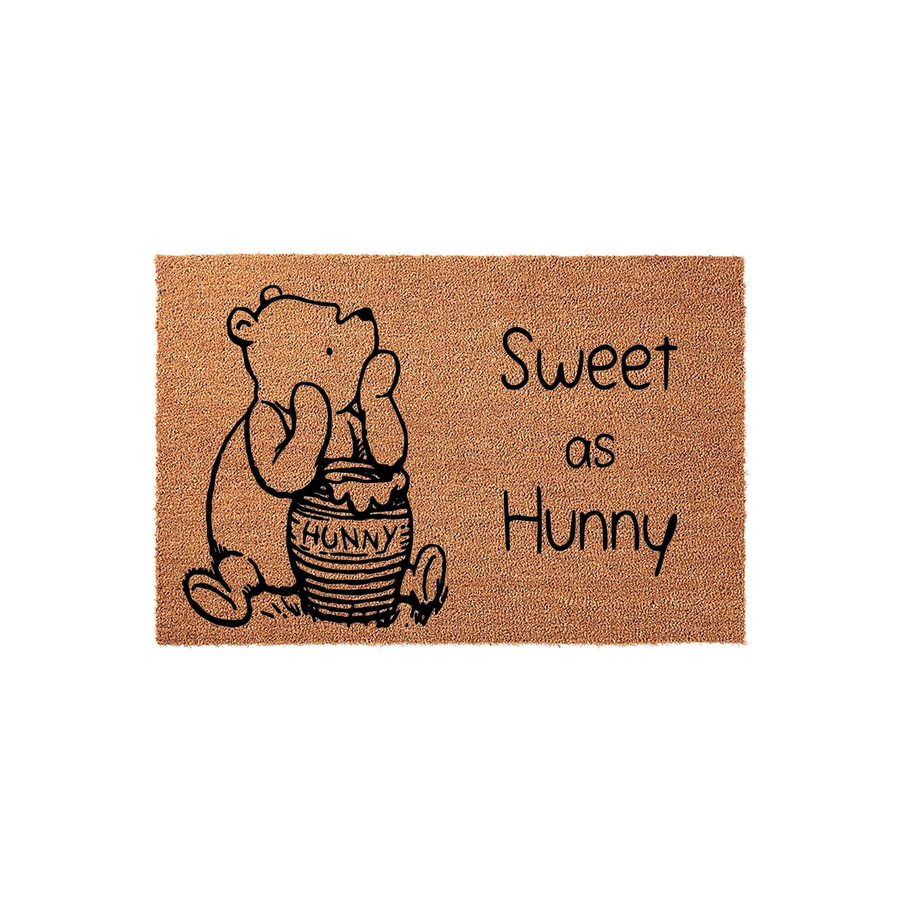 Winnie the Pooh Sweet as Hunny coir doormat featuring a classic illustration of the bear sitting by his honey pot, printed in black ink on a natural brown textured fiber surface for a charming entryway decor addition.