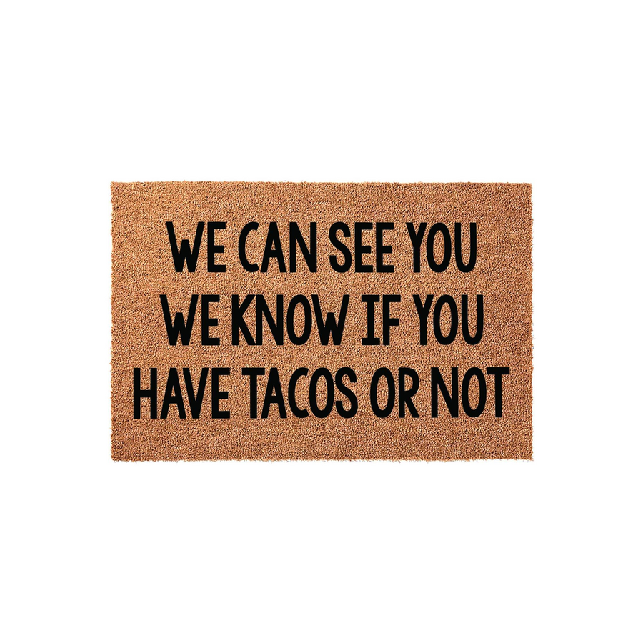 Funny Taco Welcome Doormat featuring a natural coir texture with bold black text that reads We Can See You We Know If You Have Tacos Or Not, making it a humorous front porch decor piece for any home entrance on a plain white