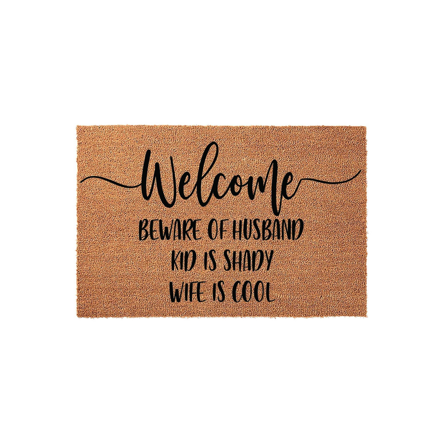 Funny Welcome Doormat featuring natural coir fibers and black text that reads Beware of Husband, Kid is Shady, Wife is Cool, making this a humorous and durable front porch decor piece for any family home entrance on a plain white