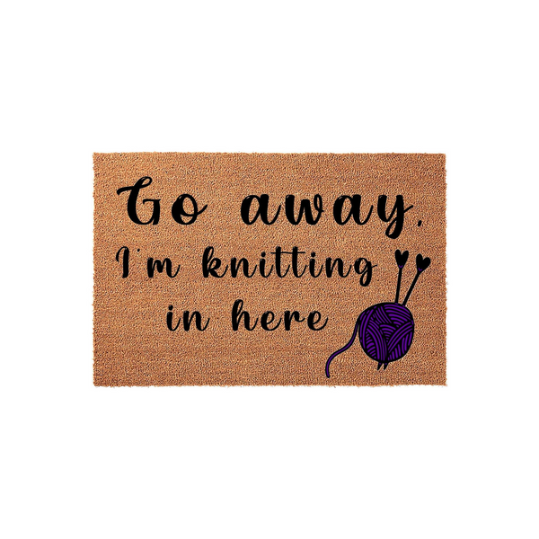 Knitting enthusiast coir doormat featuring the text Go away, I am knitting in here in black script, accompanied by a purple yarn ball and knitting needles illustration on a natural brown fiber background for a fun home entryway.