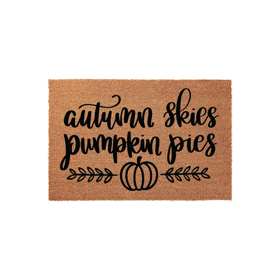 Autumn Skies Pumpkin Pies coir doormat featuring black cursive typography and a simple pumpkin icon with leafy vines, set against a natural tan fiber background for a festive seasonal porch decor look during the fall harvest