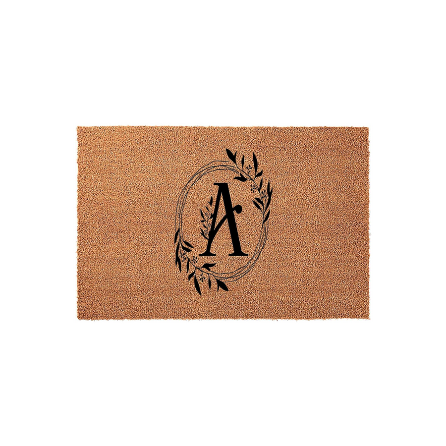 Personalized monogram coir doormat featuring a large black letter A centered inside a delicate hand-drawn botanical wreath, set against a natural brown textured fiber background for a classic and welcoming front porch entryway