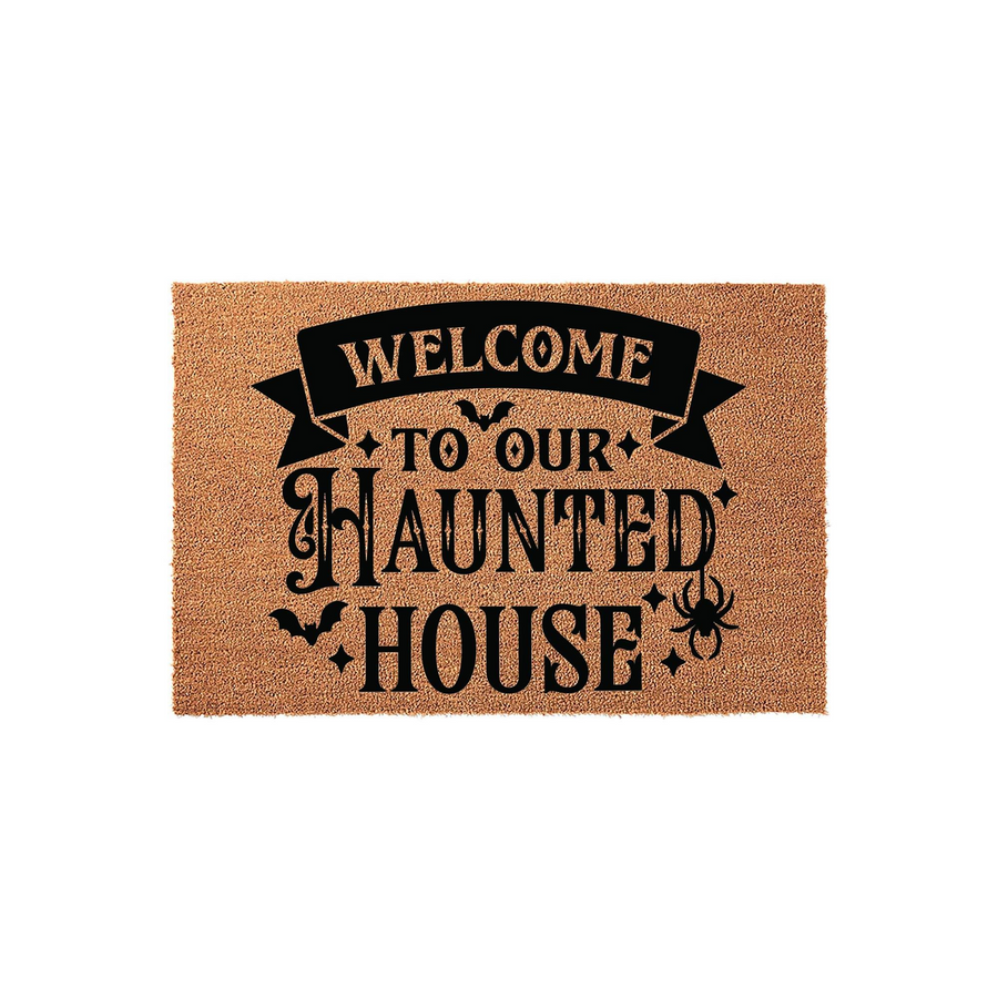 Halloween Welcome To Our Haunted House coir doormat featuring black text on a natural tan fiber background, decorated with spooky bats, stars, and a spider graphic for a festive seasonal entryway decor piece on a plain white