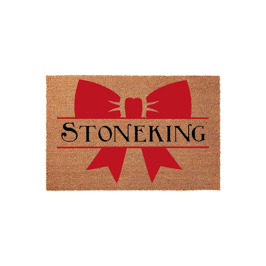 Personalized family name coir doormat featuring a large red bow graphic and a split-letter design for a custom last name, presented on a natural tan textured coir background for a festive and welcoming front porch entryway decor