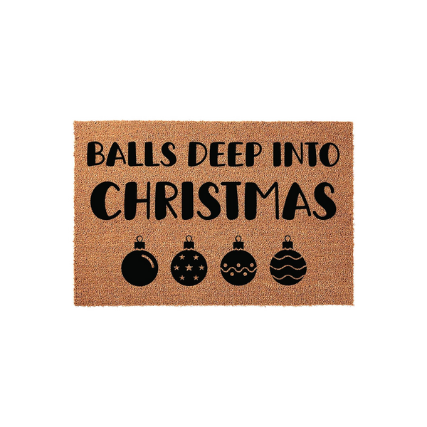Funny Christmas doormat featuring the text Balls Deep Into Christmas in bold black lettering, accented by four decorative holiday ornament icons on a natural brown coir fiber background for a festive and humorous seasonal