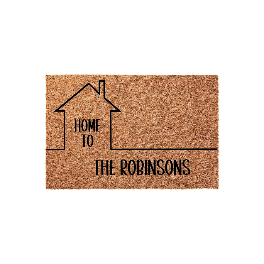 Personalized family name coir doormat featuring a minimalist house outline graphic and the text Home To The Robinsons printed in black, set against a plain white background for a clean and modern entryway decor aesthetic.