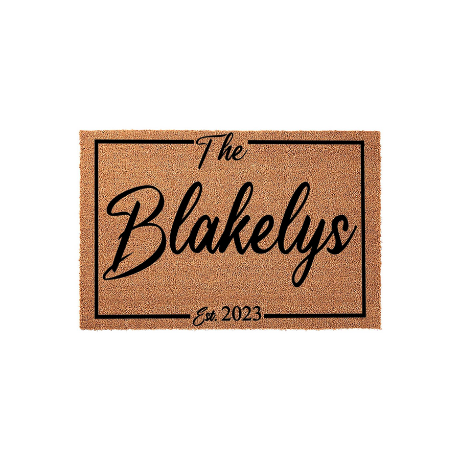 Personalized family name coir doormat featuring a classic rectangular border design with the text The Blakelys and Est. 2023 printed in elegant black script, providing a welcoming and durable entrance mat for any home front porch.