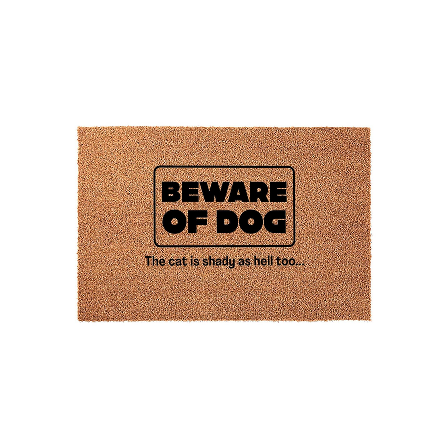 Funny Beware of Dog doormat made of natural coir fiber, featuring bold black text that reads Beware of Dog and adds that the cat is shady as hell too, perfect for a humorous entryway welcome mat on a plain white studio background.