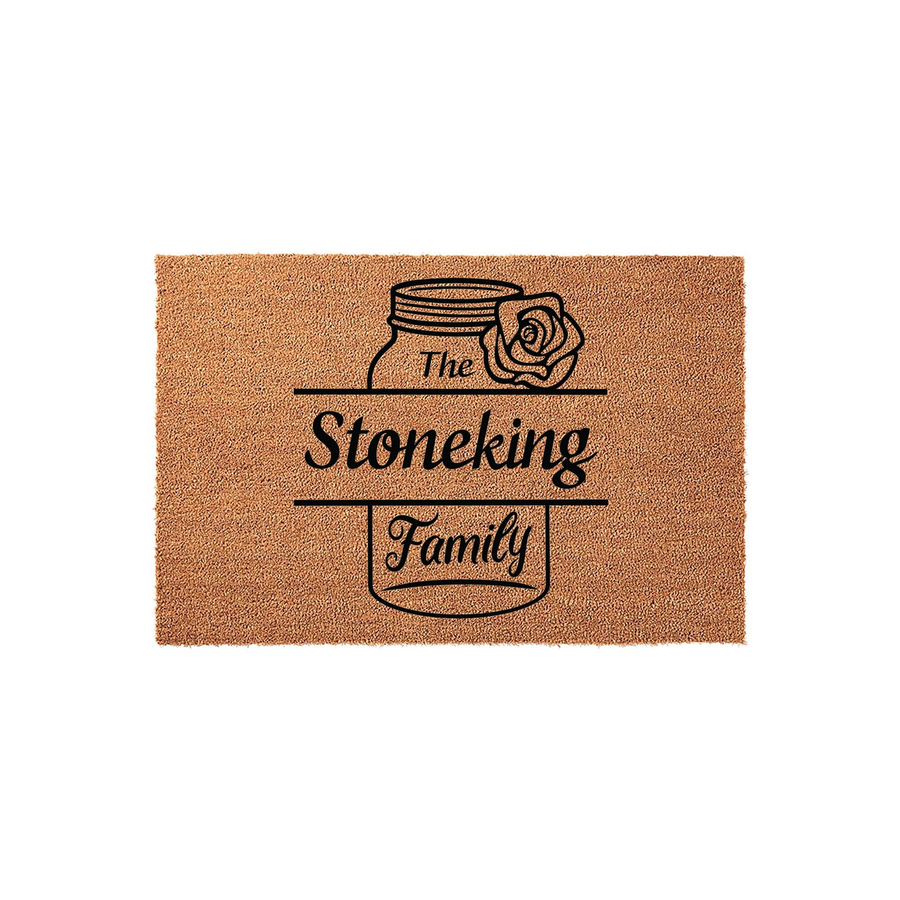 Personalized family name coir doormat featuring a rustic mason jar and rose illustration printed in black ink on a natural brown coconut fiber mat, creating a welcoming entrance decor piece for any home or housewarming