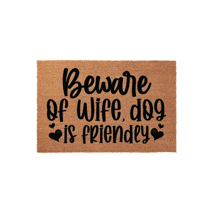 Funny Beware of Wife Dog Is Friendly doormat made of natural coir fiber, featuring bold black script lettering and decorative heart accents that add a humorous touch to your front porch entryway decor for any dog lover home.