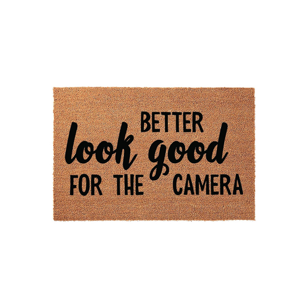 Funny Look Good For The Camera doormat featuring a natural coir fiber texture and bold black typography, displayed against a clean white background to highlight the humorous welcome message for your front porch or entryway decor.
