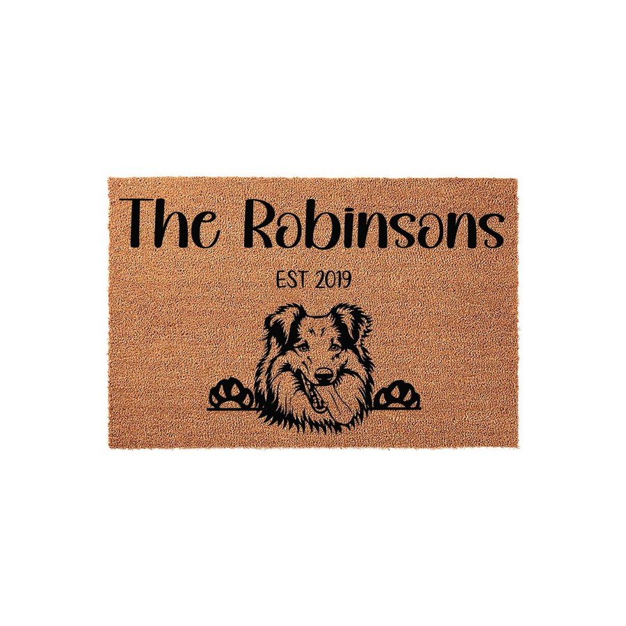 Personalized Collie Dog Doormat featuring a natural coir texture with a black printed illustration of a happy Collie dog peeking over the bottom edge, customized with a family name and an established year on a clean white
