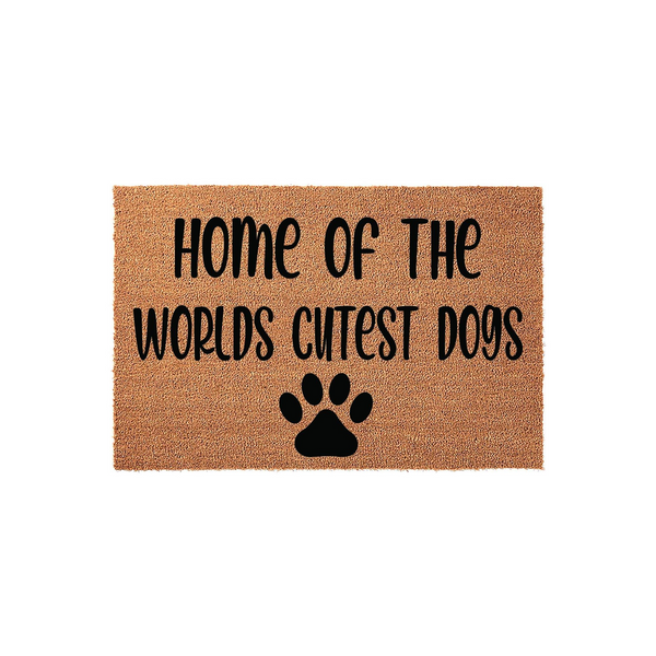 Home of the Worlds Cutest Dogs coir doormat featuring a natural tan fiber texture and bold black lettering that reads Home of the Worlds Cutest Dogs, accented by a single black paw print icon centered at the bottom on a white