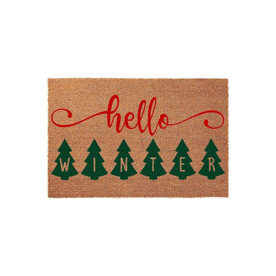 Hello Winter Christmas doormat made of natural coir fiber, featuring a festive red script font above six green pine trees that each contain a letter spelling out the word winter against a plain white background for holiday home