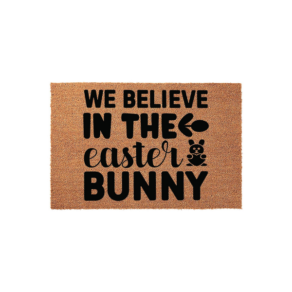 Easter Bunny coir doormat featuring the text We Believe In The Easter Bunny in bold black lettering, complete with a cute bunny graphic and an egg icon to add a festive touch to your front porch decor for the spring holiday