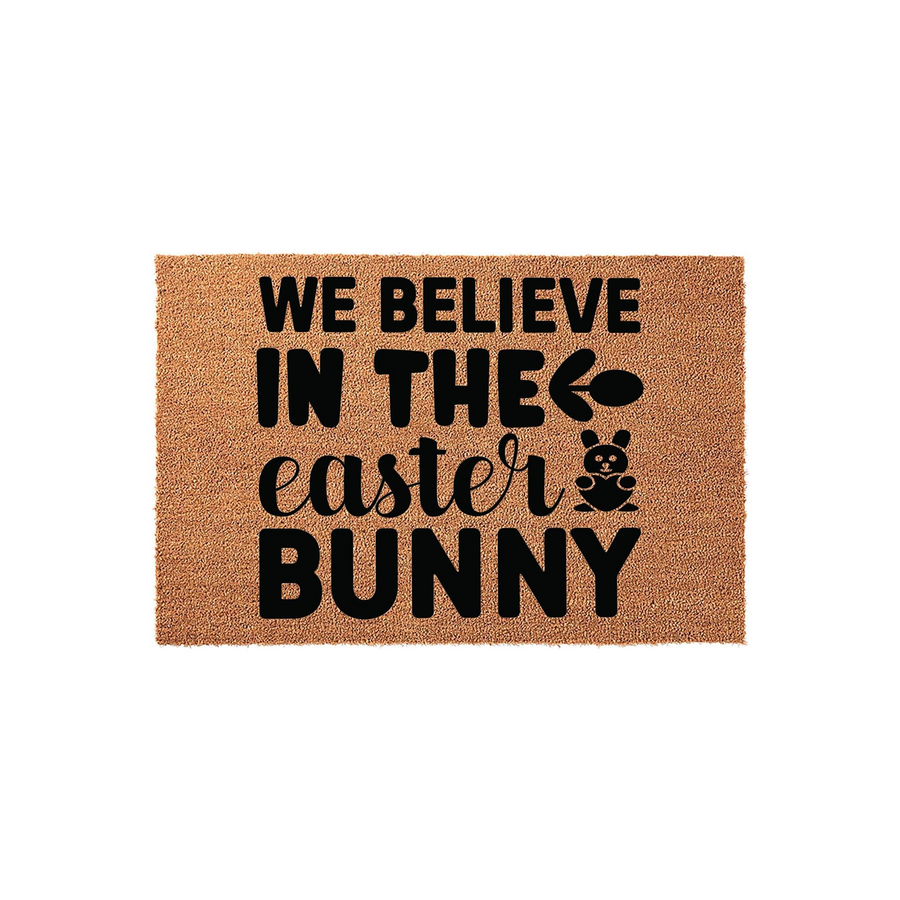 Easter Bunny coir doormat featuring the text We Believe In The Easter Bunny in bold black lettering, complete with a cute bunny graphic and an egg icon to add a festive touch to your front porch decor for the spring holiday