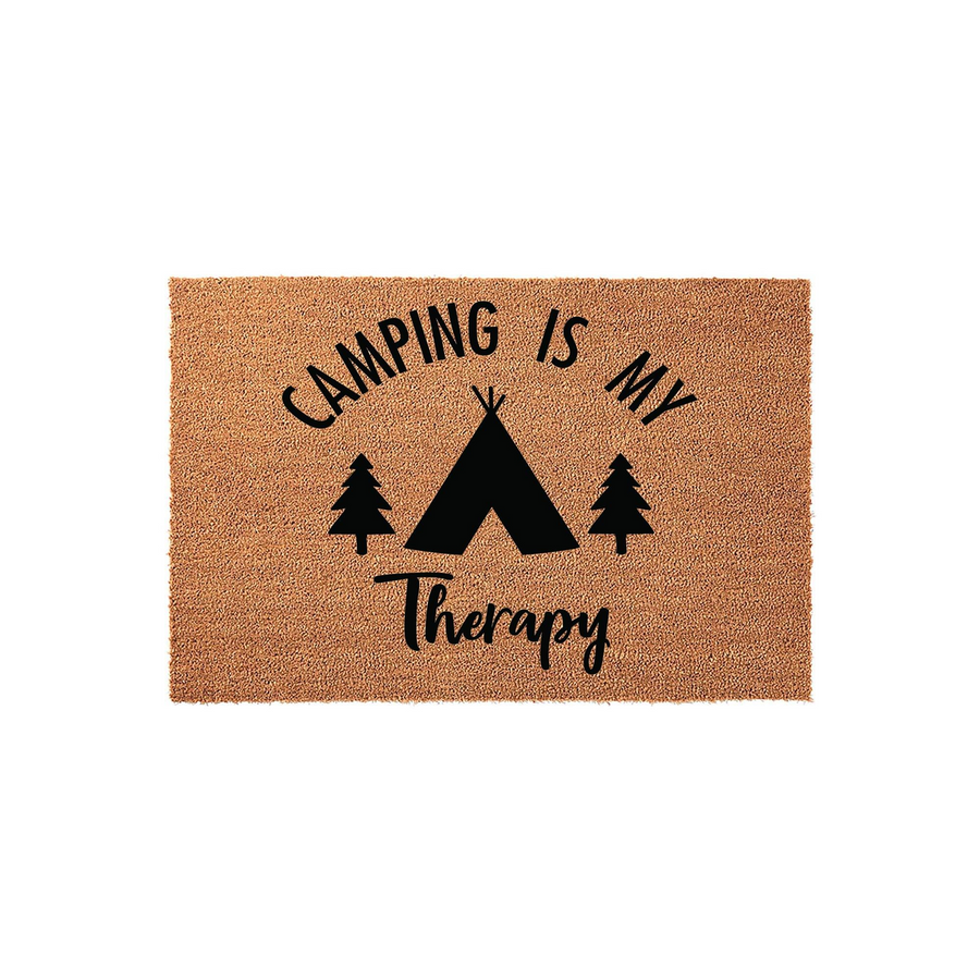 Camping Is My Therapy coir doormat featuring a black printed design of a tent and pine trees on a natural brown fiber background, perfect for an outdoor entrance or a camper trailer door to show off a love for the great outdoors.