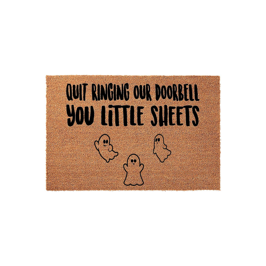 Funny Halloween doormat featuring a natural coir texture with the text Quit Ringing Our Doorbell You Little Sheets printed in black, accompanied by three cute ghost illustrations for a festive and spooky seasonal home entryway