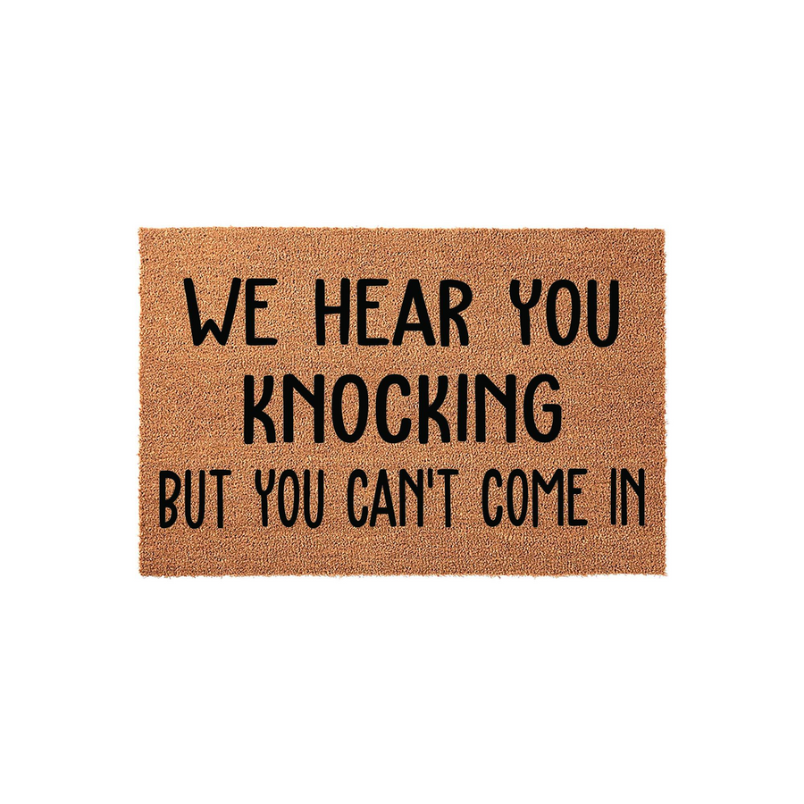 Funny We Hear You Knocking But You Can't Come In doormat featuring bold black text printed on a natural brown coir fiber mat, shown against a clean white background for a modern and humorous entryway decor style for your front