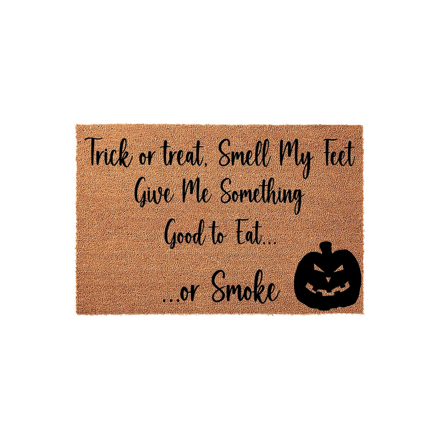 Funny Halloween doormat made of natural coir fiber, featuring the playful text Trick or Treat, Smell My Feet, Give Me Something Good to Eat... or Smoke, accompanied by a black jack-o-lantern pumpkin graphic on a plain white