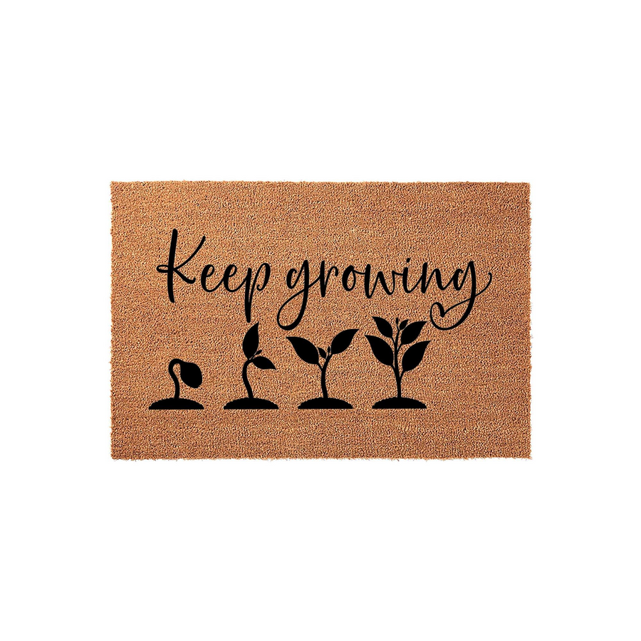 Keep Growing Coir Doormat featuring a natural tan fiber texture with black text and a graphic showing the stages of plant development from a small sprout to a leafy plant, creating a welcoming and inspirational entryway floor mat.