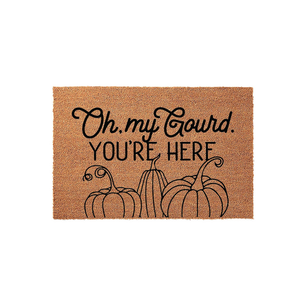 Oh My Gourd You Are Here fall doormat made of natural coir fiber, featuring a playful black script and block letter design with three illustrated pumpkins at the bottom for a festive autumn porch decor look on a plain white