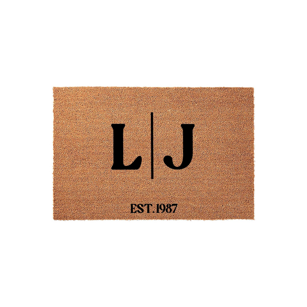 Personalized coir doormat featuring a custom monogram with two large black letters separated by a vertical line and the established year printed below, set against a clean white background for a classic home entryway decor