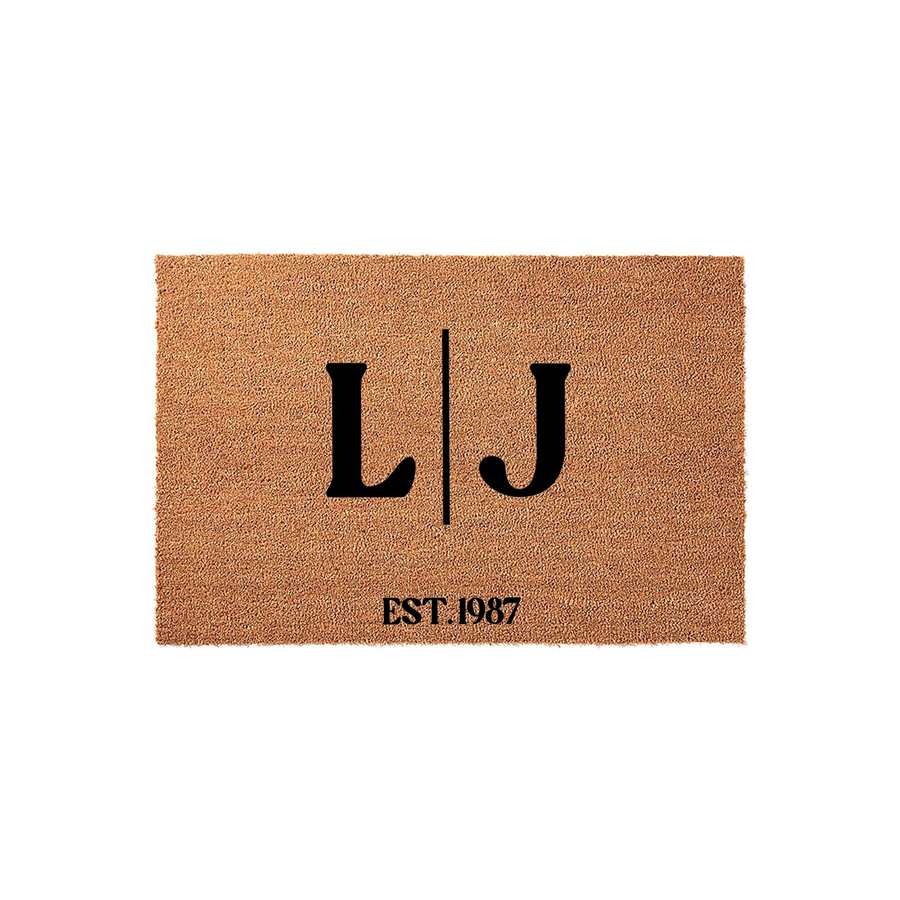 Personalized coir doormat featuring a custom monogram with two large black letters separated by a vertical line and the established year printed below, set against a clean white background for a classic home entryway decor
