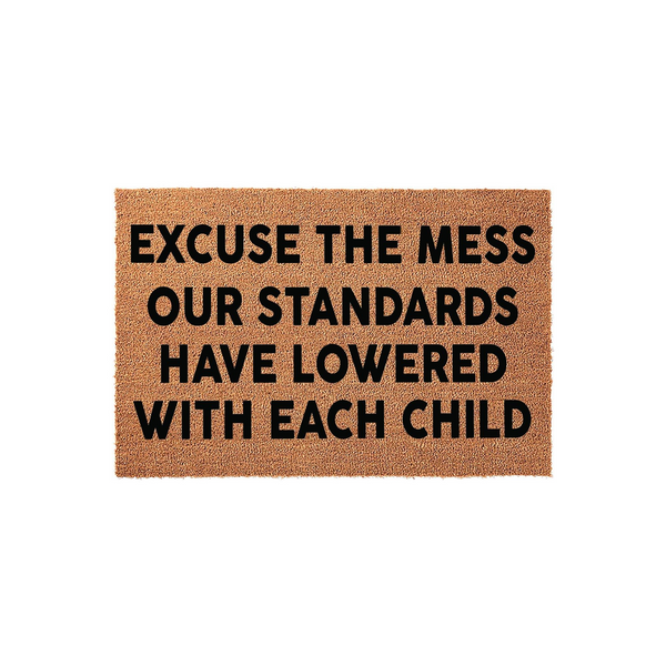Funny Excuse the Mess Our Standards Have Lowered With Each Child doormat made of natural coir fiber, featuring bold black text centered on a rectangular brown mat that adds a humorous touch to any home entryway or front porch
