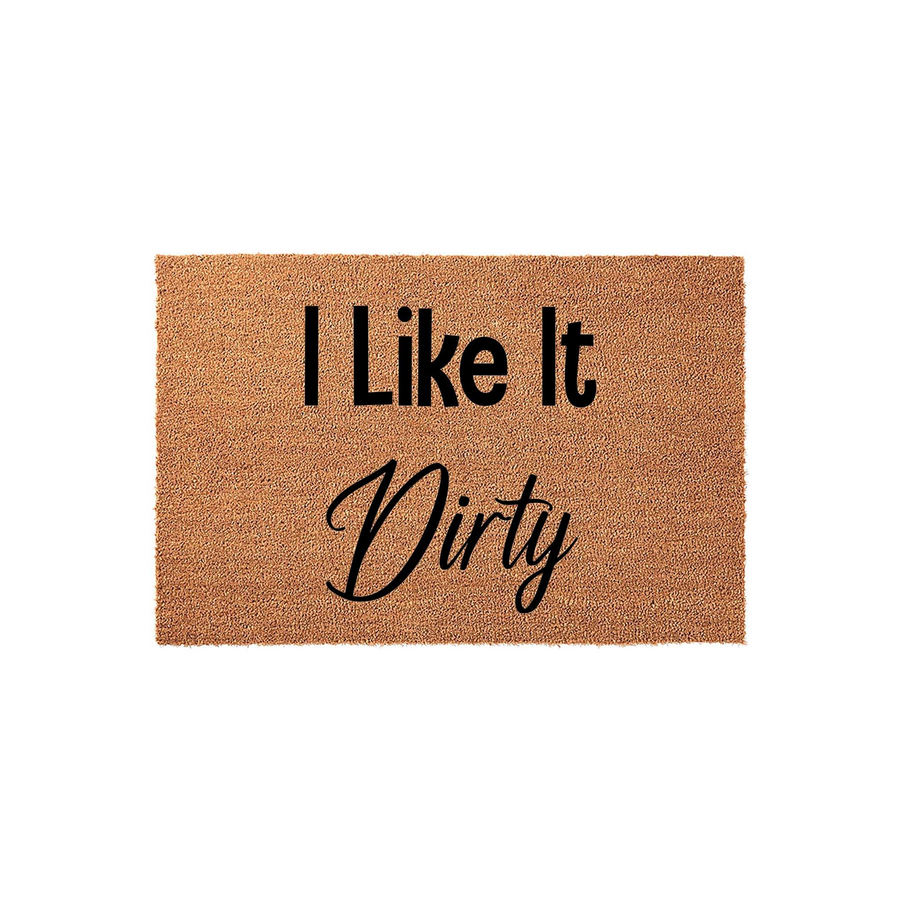 I Like It Dirty funny doormat made of natural coir fibers with a textured surface, featuring bold black text that reads I Like It Dirty in a mix of modern sans-serif and elegant script fonts against a plain white studio