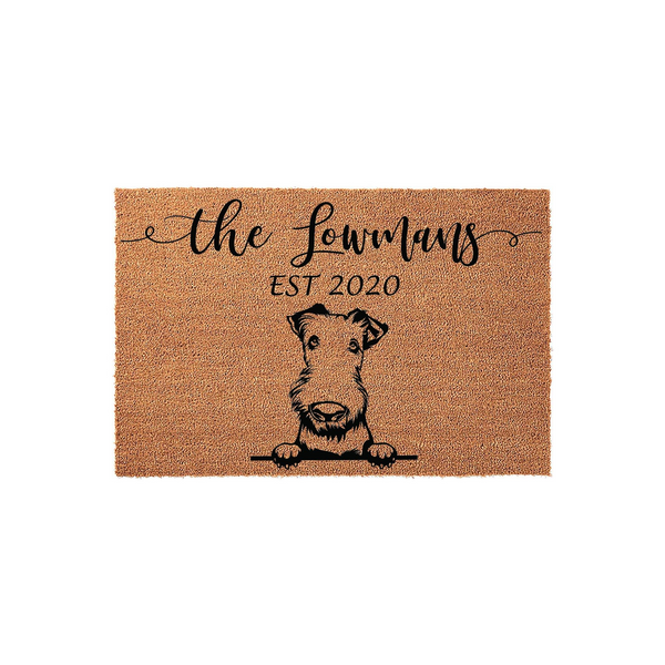 Personalized Airedale Terrier doormat featuring a cute dog illustration peeking over a line, with custom family name text and established year printed in black on a natural brown coir fiber mat for a welcoming front porch