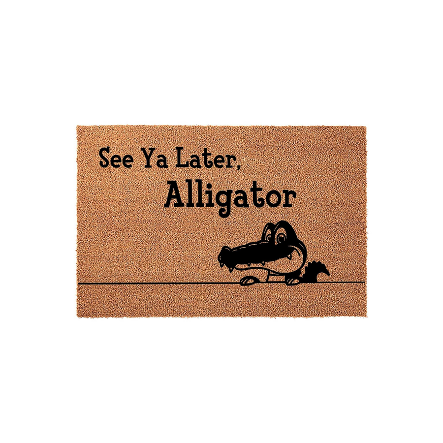 See Ya Later Alligator Coir Doormat featuring a playful cartoon alligator illustration printed in black ink on a natural brown textured fiber mat, creating a fun and welcoming entrance for your front porch or home entryway decor.
