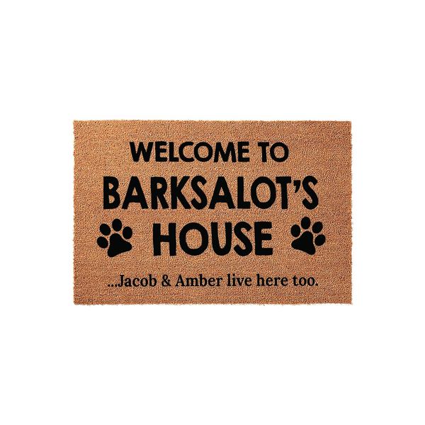 Personalized Dog Lover Coir Doormat featuring the text Welcome to Barksalot's House with black paw print icons and a secondary line noting that the humans live here too, set against a clean white background for a pet-friendly