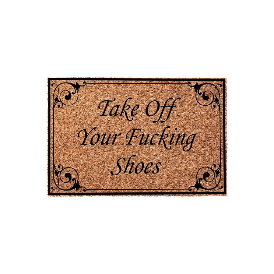 Funny doormat with a natural coir texture featuring a black border and elegant scrollwork corners, displaying the bold text Take Off Your Fucking Shoes in a classic serif font against a plain white studio background for a modern