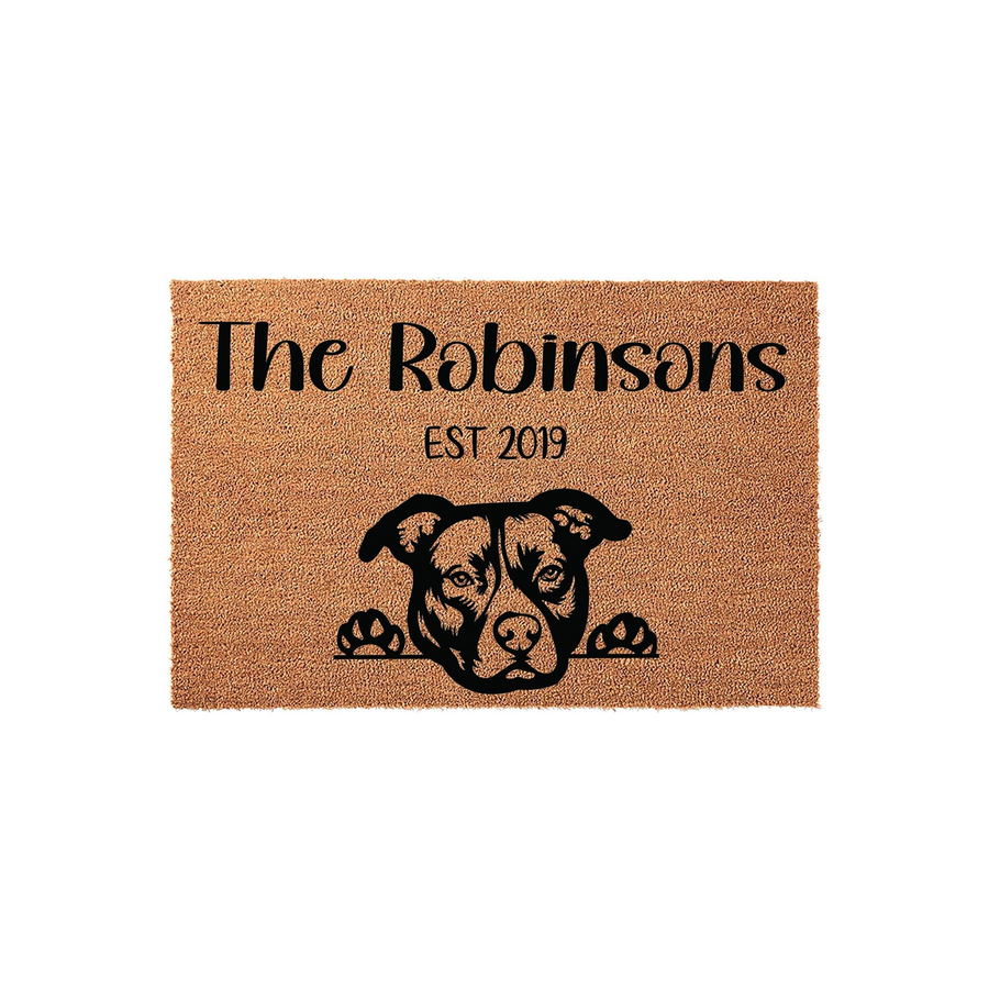 Personalized Pit Bull doormat featuring a natural coir texture with a black printed illustration of a dog peeking over the edge, customized with a family name and established year on a clean white background for a welcoming home