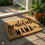 Grateful Mama coir doormat featuring black script and block lettering on a natural fiber welcome mat, perfect for a front porch entry or home decor, with arrow accents adding a stylish touch to this durable outdoor floor rug.