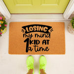 Funny parent doormat with the text Losing my mind 1 kid at a time, featuring a natural coir fiber welcome mat design for a front porch entrance, perfect for a humorous home decor gift for moms or dads who need a laugh at the door.
