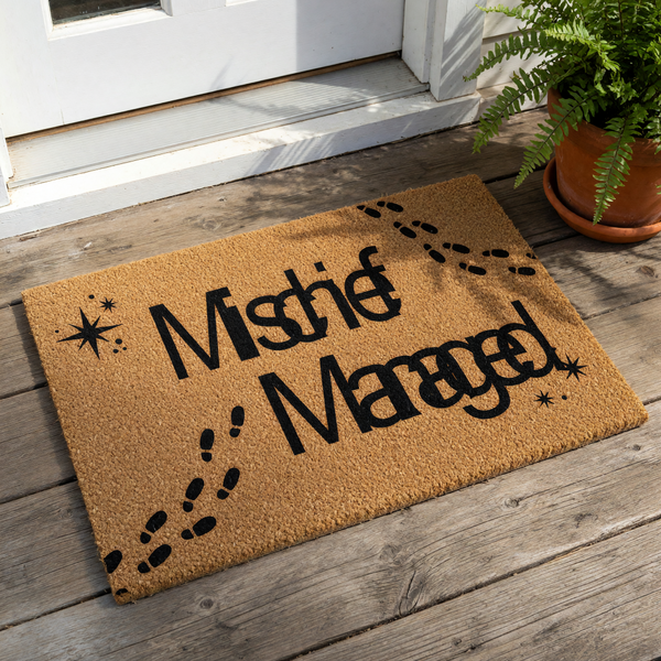 A doormat with the text "Mischief Managed" printed on it, along with footprints and stars.