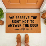 Funny doormat with the text We Reserve The Right Not To Answer The Door, a natural coir fiber welcome mat for front porch decor that makes a humorous housewarming gift for any home entrance, featuring a simple floral design