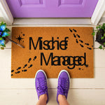 A rectangular door mat with the text "Mishief Managed" printed on it, along with footprints and stars.