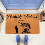 Probably Fishing doormat featuring a black silhouette of a fisherman and a large bass fish on a natural coir welcome mat, perfect for a front porch entry, outdoor decor, or a fun housewarming gift for any avid angler or fisherman.